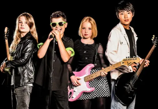 Group of young musicians performing with guitars and a microphone, showcasing youth band music lessons and live performance programs at Rockstars of Tomorrow.