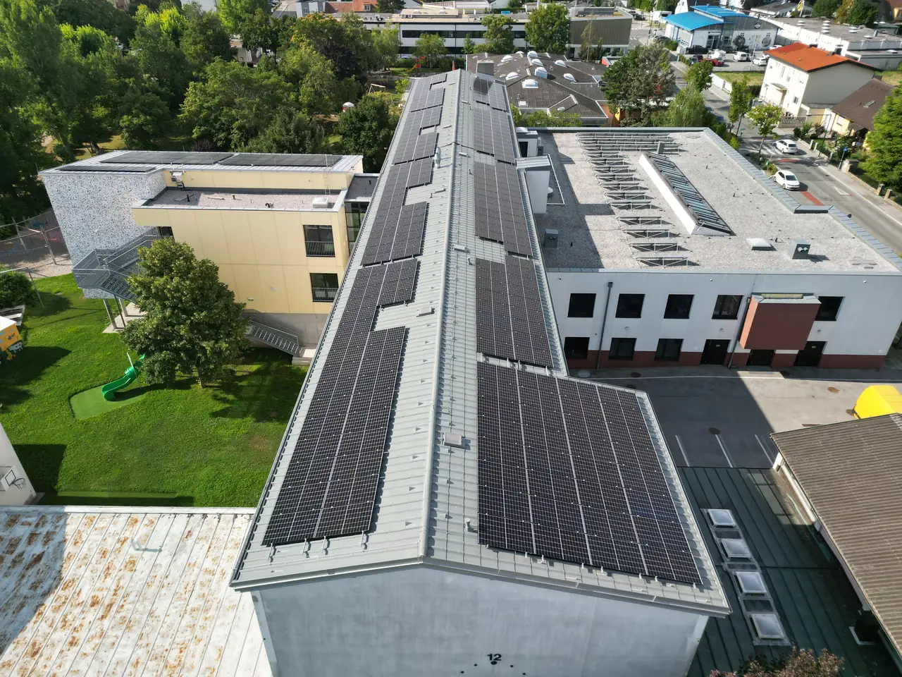 A képen Dóc városában található napelem telepítés látható, amelyet az Ares Solar Construction Kft. végzett. A tetőn elhelyezett napelemek sorakoznak, míg a környező zöld területek és épületek is megfigyelhetők. A napelem kivitelezés modern megoldásokat tükröz, amelyek segítik a fenntartható energia előállítást.