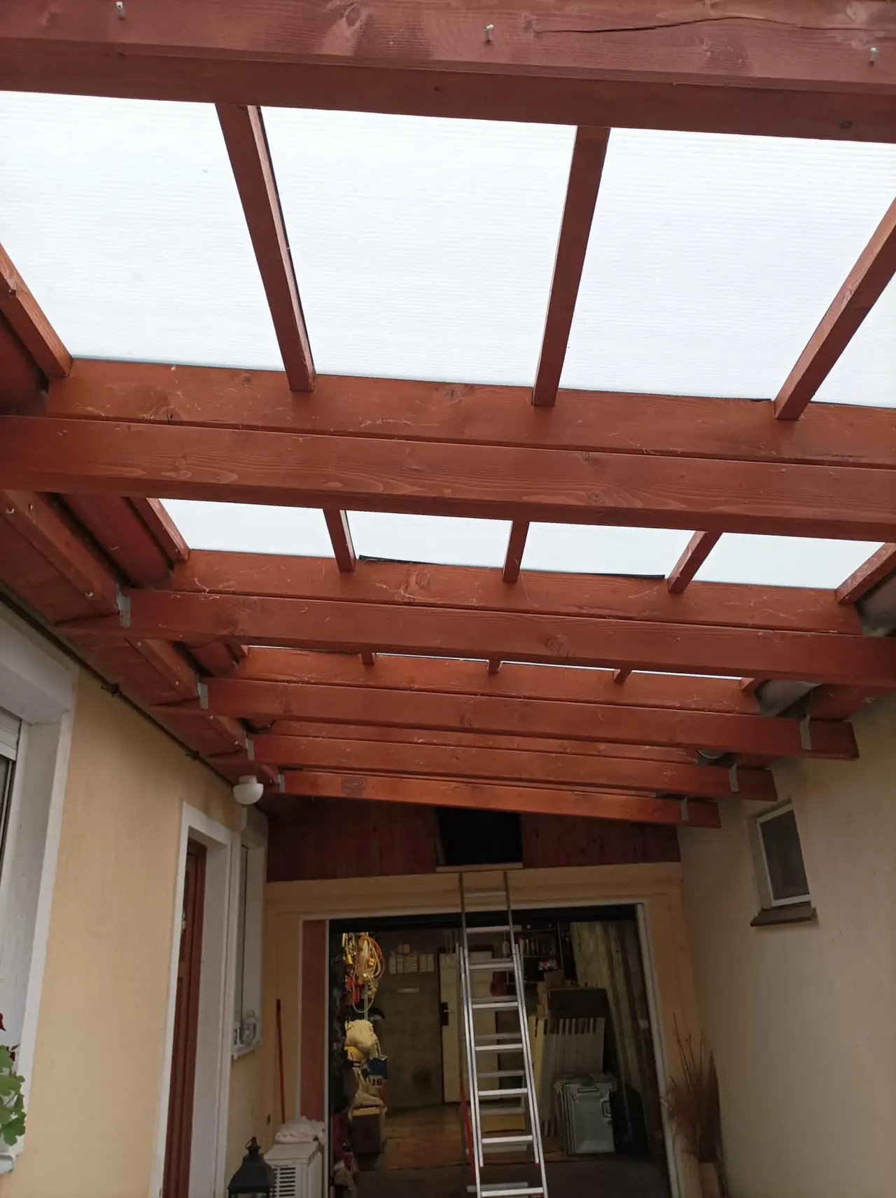 A képen egy napelemes rendszer telepítése látható egy Dócon található ház teraszán. A fa szerkezetű pergola alatt a napelemek helyét előkészítik, miközben a létra is látható, amely a munkaterület elérését segíti. Az Ares Solar Construction Kft. napelem telepítési szolgáltatása kiemelkedő figyelmet fordít a részletekre, biztosítva a napelemes rendszerek hatékony felügyeletét.