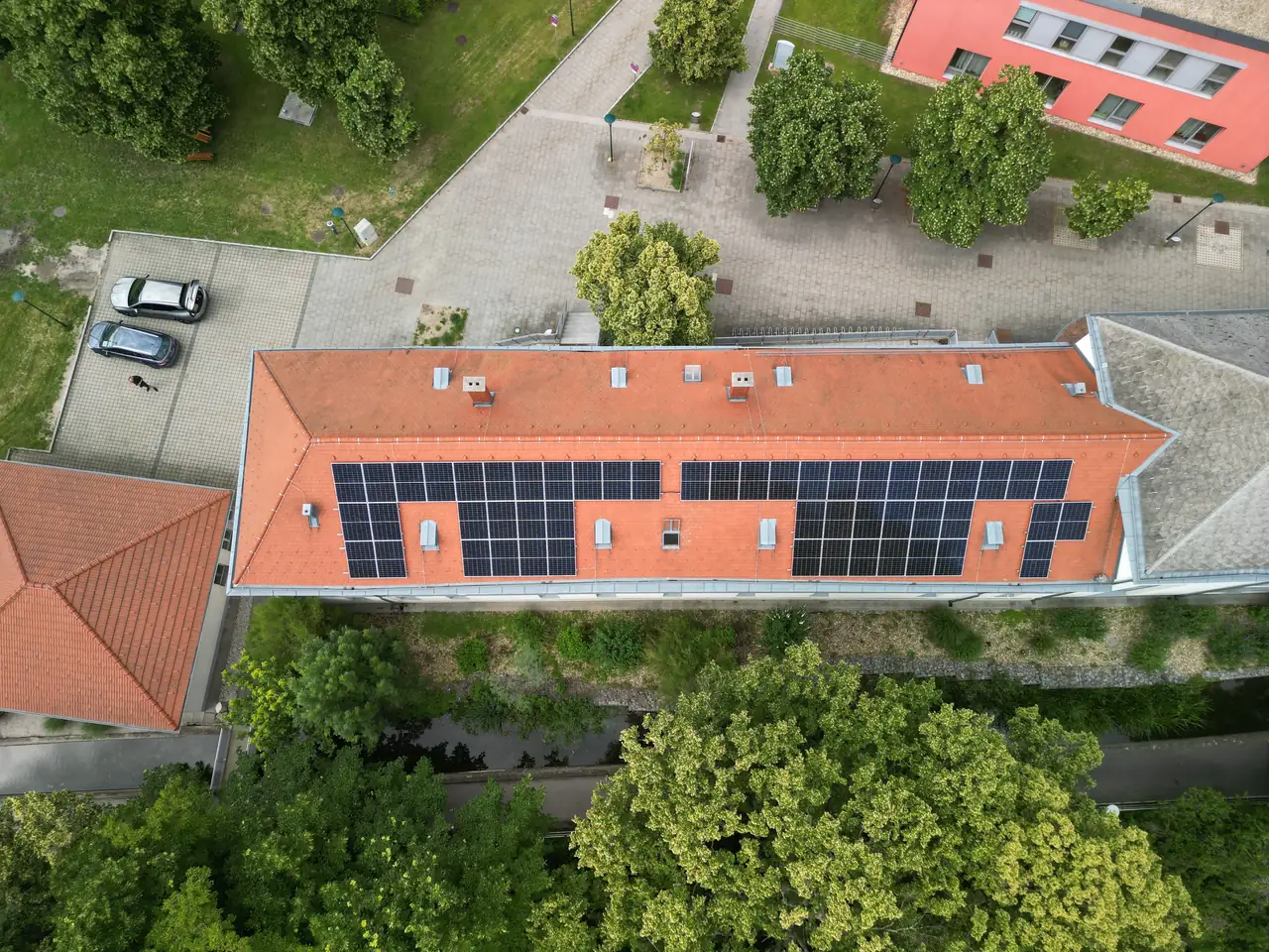 A képen egy Debrecenben található épület tetője látható, amelyen napelemek sorakoznak.
