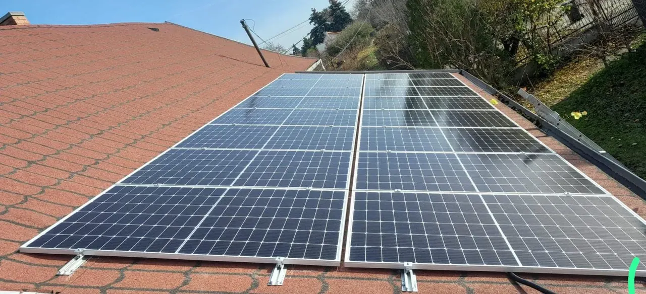 A képen a Dóc településen található Ares Solar Construction Kft. napelem telepítési szolgáltatása látható. A tetőn elhelyezett napelemek sorakoznak, amelyek napfényenergia begyűjtésére szolgálnak. A napelemek kiváló minőségű anyagokból készültek, és szakszerűen lettek felszerelve a tetőre, hogy maximális hatékonyságot biztosítsanak.