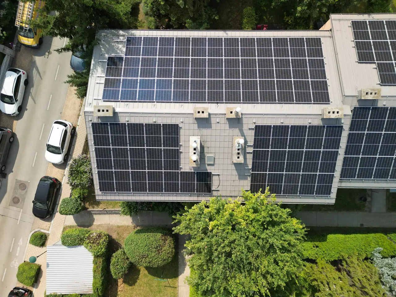 Hódmezővásárhelyen található Ares Solar Construction Kft. napelem telepítési projektje látható a képen. A ház tetején elhelyezett napelemek sorakoznak, amelyek napfényt hasznosítanak, környezetbarát energia előállításához. A zöld növényzet és a rendezett kert hangsúlyozza a fenntartható megoldások iránti elkötelezettséget, ami a modern városi élet részét képezi.