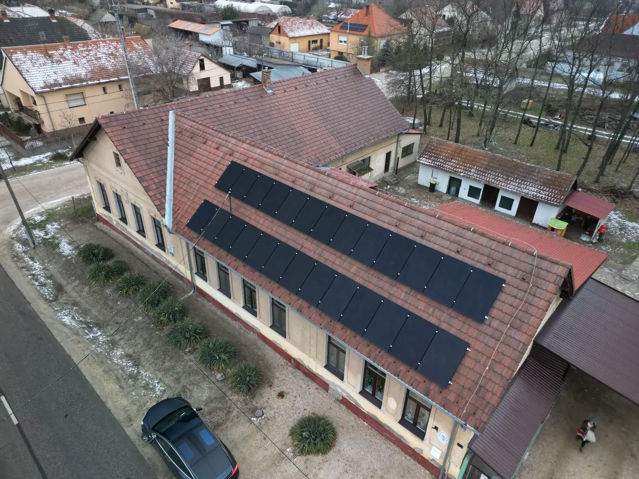 A képen egy budapesti épület tetőjén elhelyezett napelemek láthatók, amelyeket az Ares Solar Construction Kft. telepített.