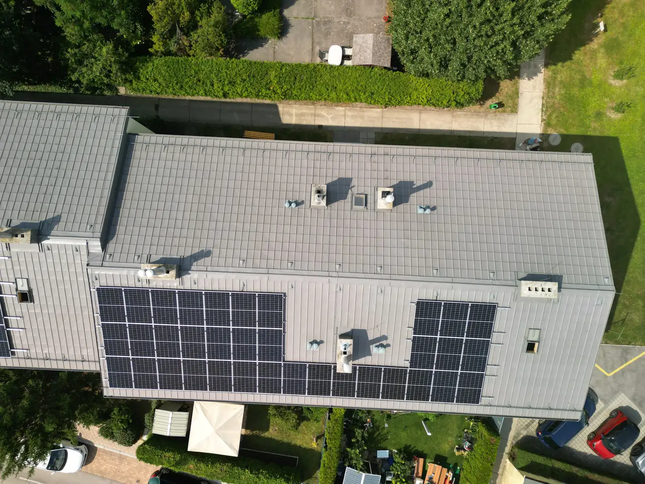 Békéscsabán található Ares Solar Construction Kft. napelem telepítési projektje látható az épület tetején, ahol több sor napelem van felszerelve. Az épület körül gondozott zöld területek és parkolóhelyek találhatók, ami jól mutatja a modern és fenntartható energiafelhasználás iránti elkötelezettséget. A telepítés professzionális kivitelezése hozzájárul a környezetbarát energiahasználathoz.