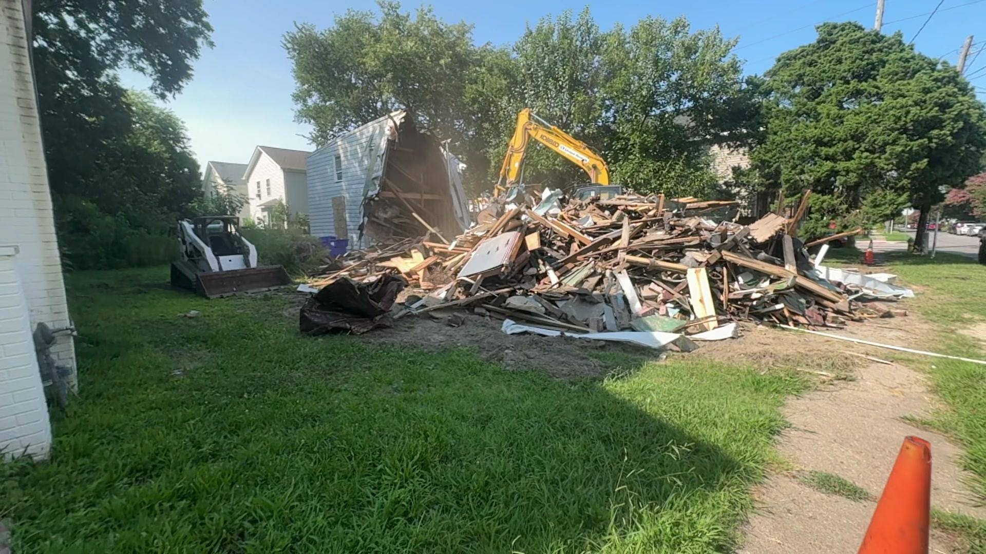 Aerial drone view of a demolition site with debris and an excavator