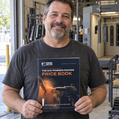The owner-operator of a Central Florida powder coating shop holding the printed Price Book in his shop