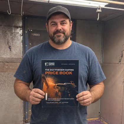 The lead powder coater at a Western Pennsylvania custom finishing shop holding the Price Book in the booth