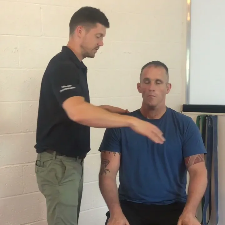 Proprioception screen: practitioner testing a seated client's arm