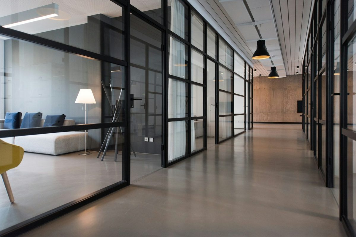Interior de oficina con despachos acristalados y luz natural