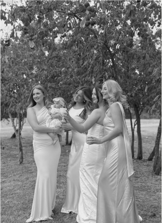 Bridesmaids in satin gowns under a tree