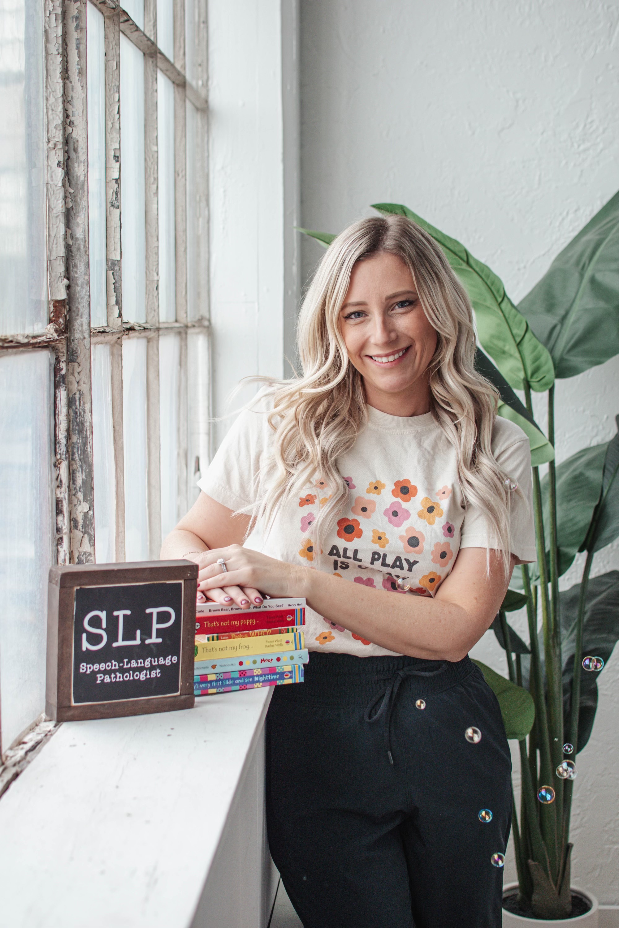 Jillian Lenhard, M.S.Ed., CCC-SLP/L, founder of The Speech Path, holding children's books