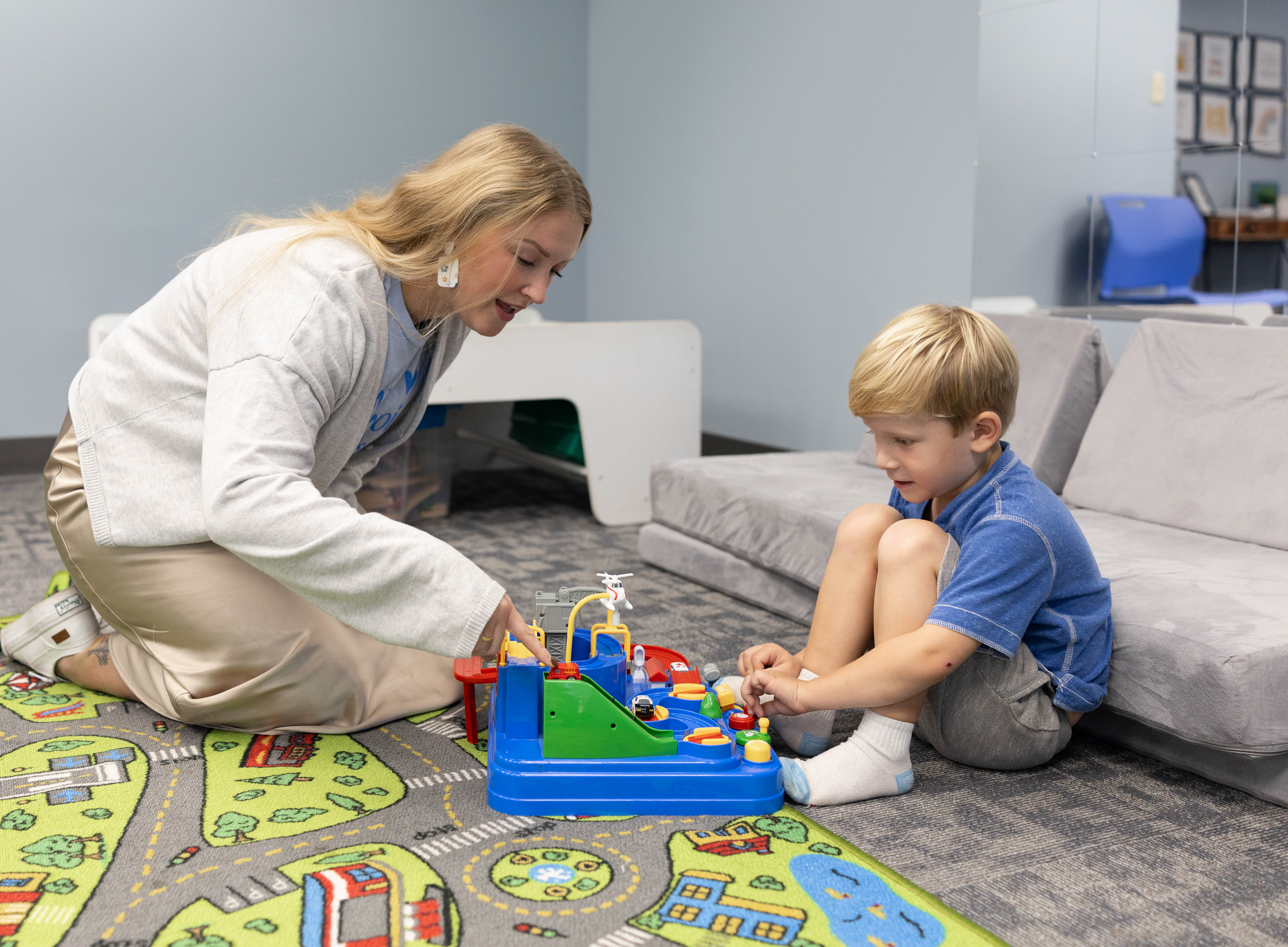 SLP and child playing together on the floor with toys