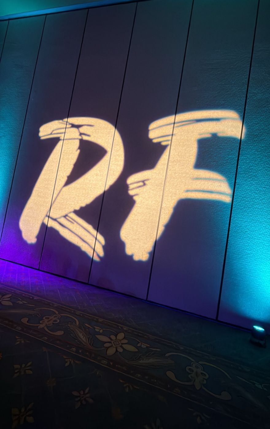 Event logo glowing on a stage wall at a corporate conference