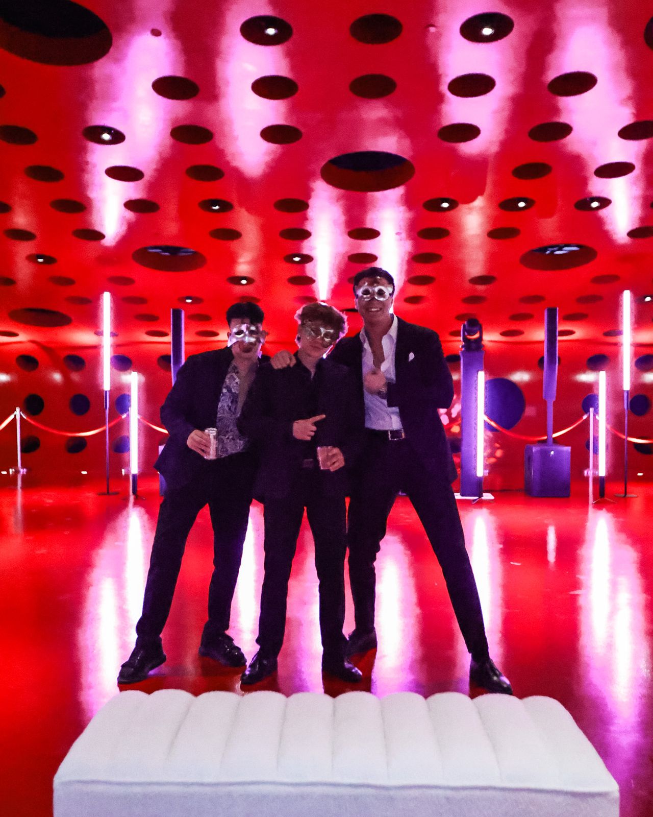 A company team posing on stage in front of glowing LED tubes
