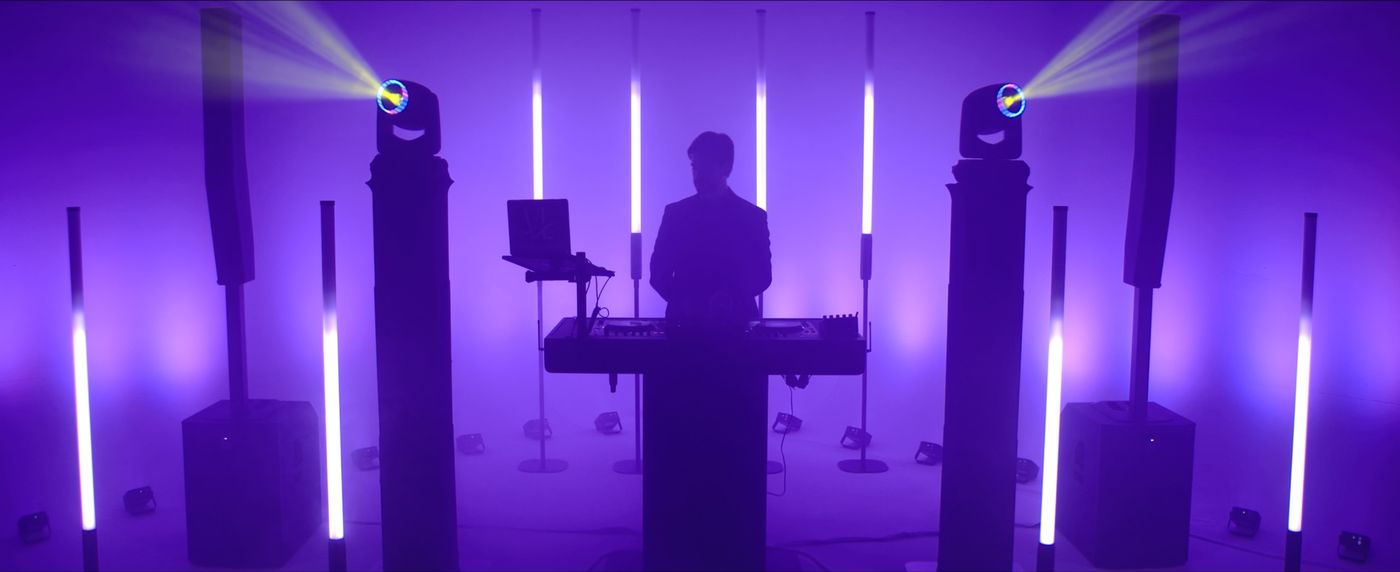 DJ booth framed by glowing purple LED tubes