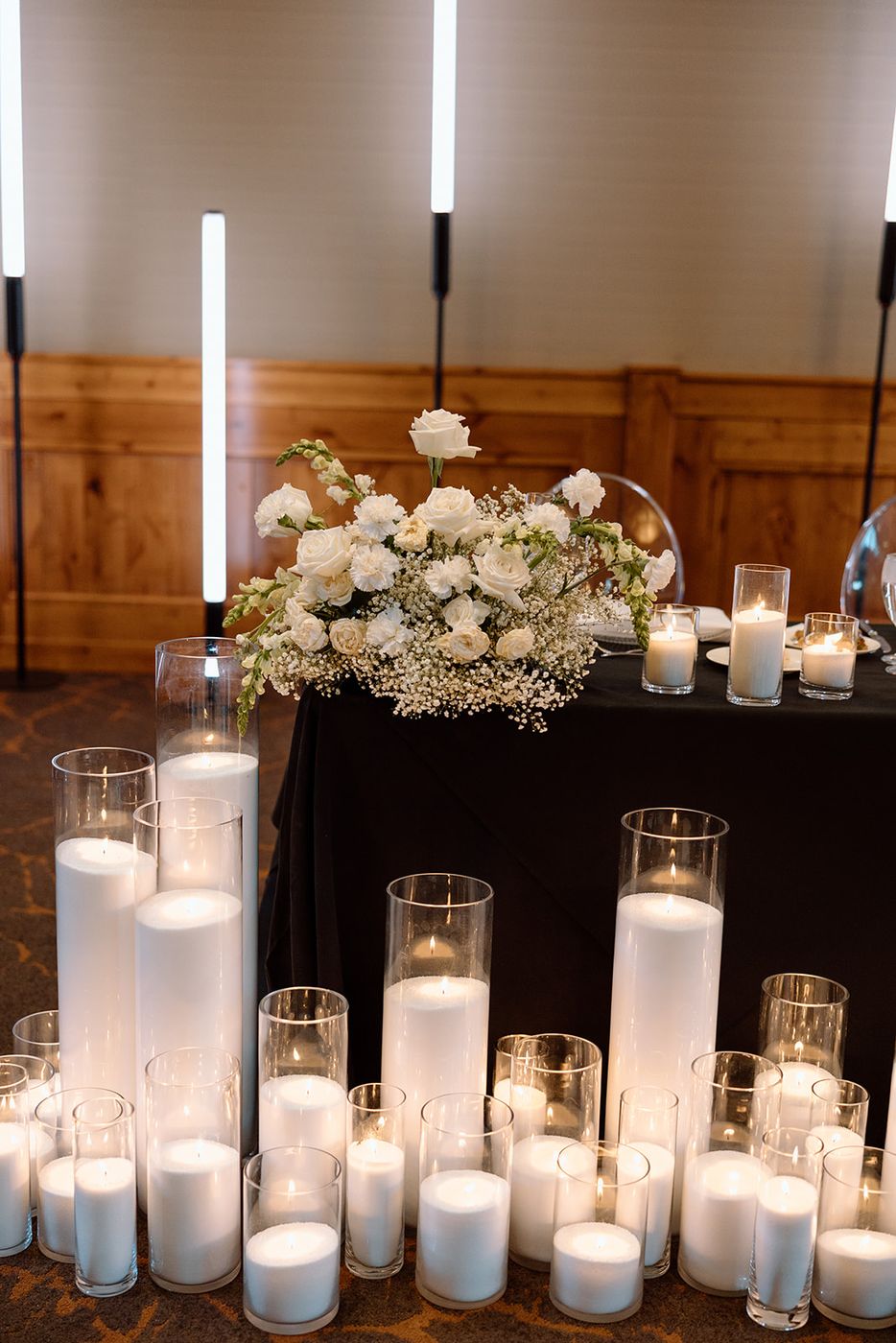 Head table surrounded by dozens of pillar candles