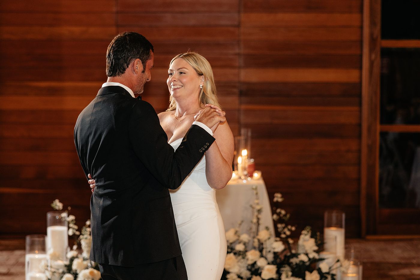 First dance in a wood-paneled lodge with candles behind