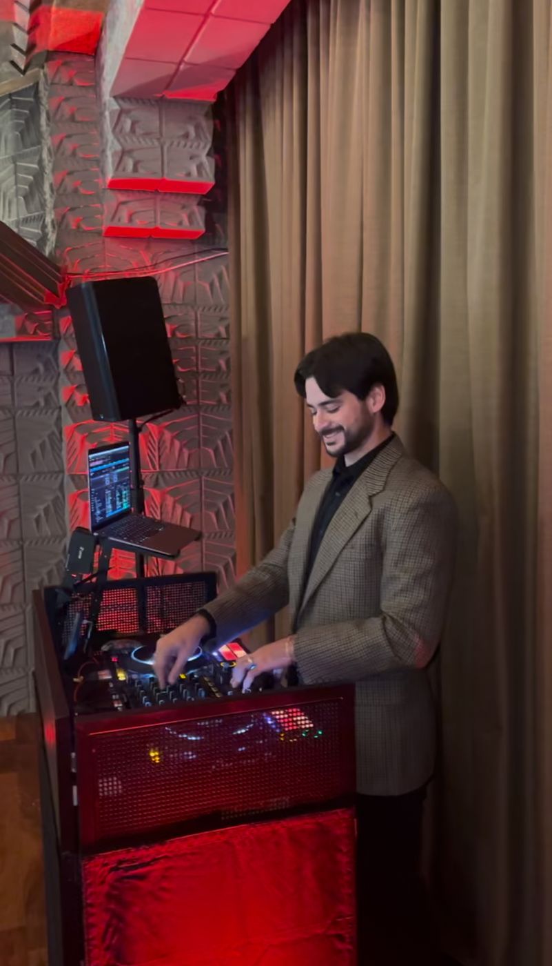 The DJ mixing at a sweet sixteen house party under red light