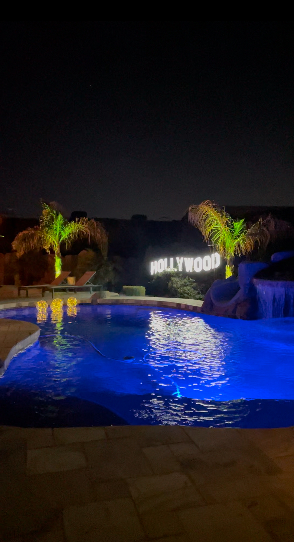 A backyard party by the pool at night.