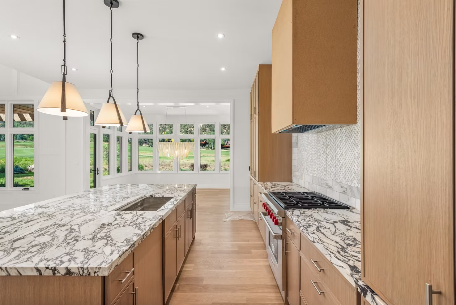 Newly installed stone countertop in a mountain-modern kitchen in the Roaring Fork Valley, with natural light from large windows highlighting the slab surface and custom cabinetry below. The finished countertop runs the full length of the kitchen island, with clean seams and a polished edge profile.
