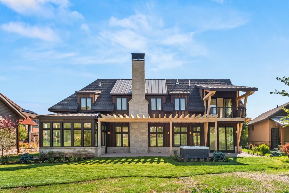 A newly completed custom home built by Pegasus Custom Homes on a mountain lot in the Roaring Fork Valley, with a stone and timber exterior suited to the Colorado high-country landscape. The home features large windows, a steep-pitch roof designed for heavy snow loads, and a site-fitted foundation on sloped terrain.