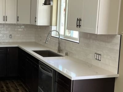 Modern kitchen with a white subway tile backsplash and sleek white cabinetry, offering a clean and contemporary look.