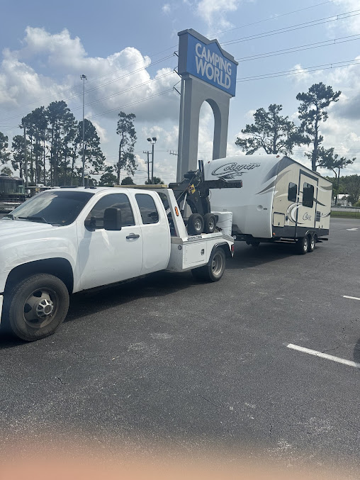 Moffo's Towing flatbed truck loaded with a vehicle on a tow job in Lake City, FL