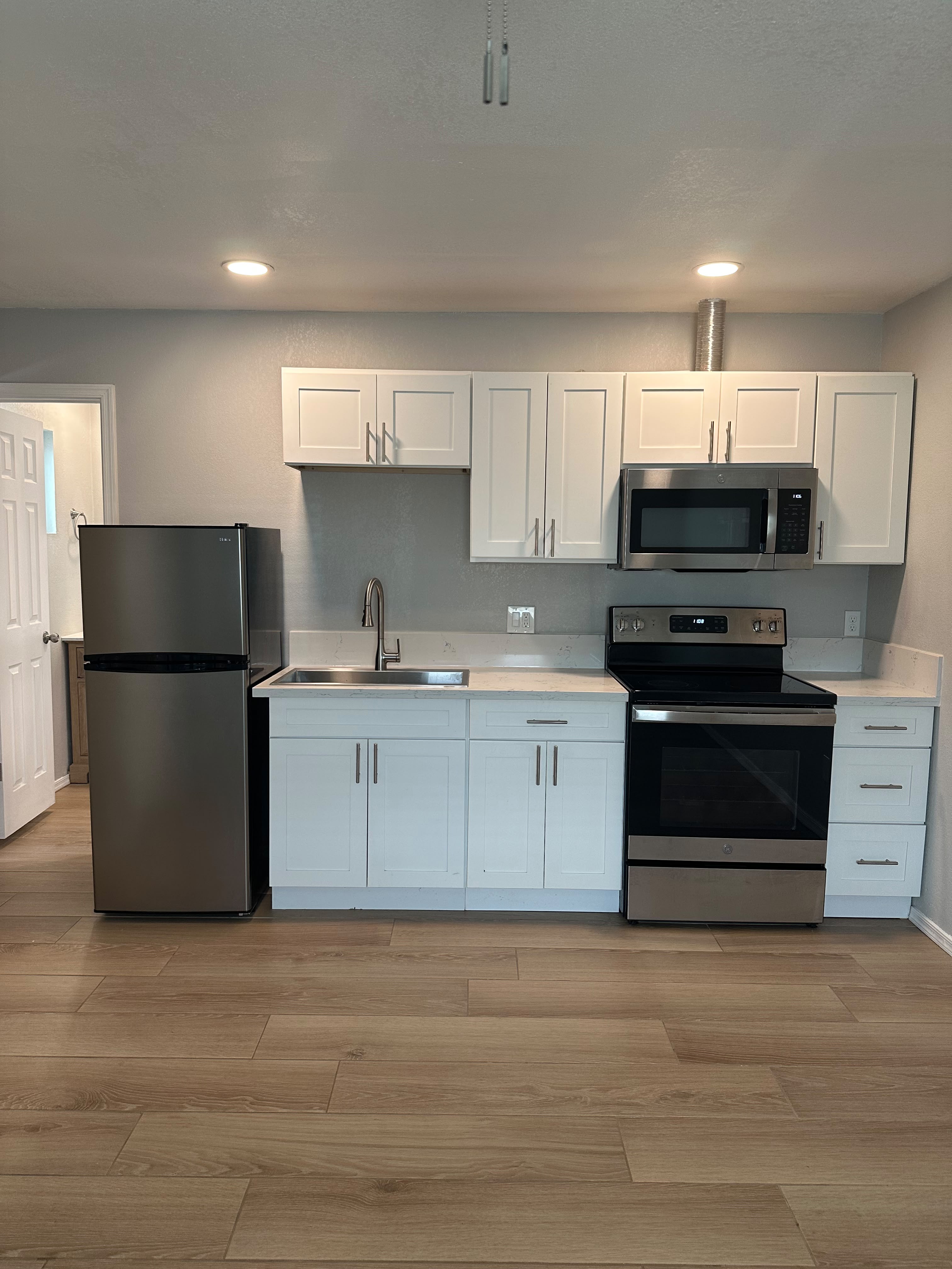 Cocina equipada con estufa, refrigerador y microondas