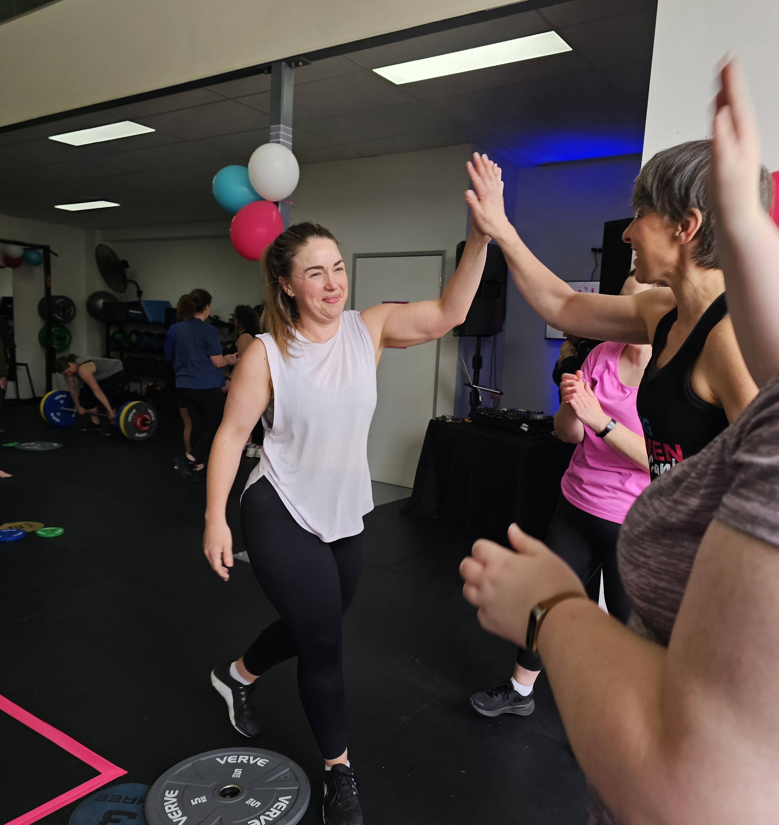 Members high-fiving after a class at Strong Women Can
