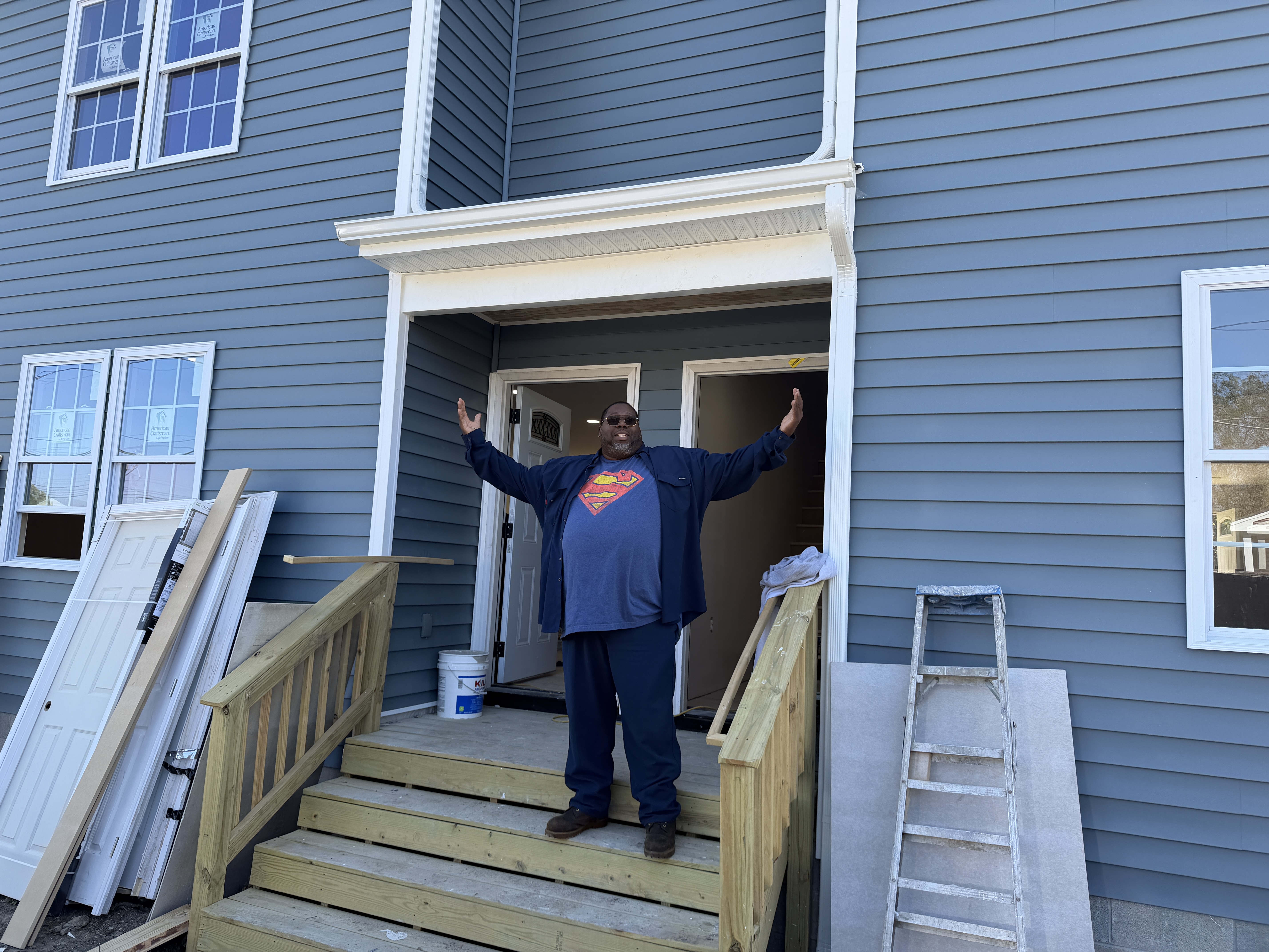 Satisfied client in front of a new construction home built by Solutions GC in Chester, Virginia