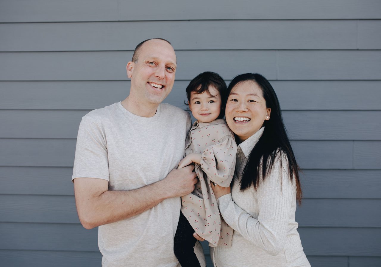 Family standing in front of a suburban home