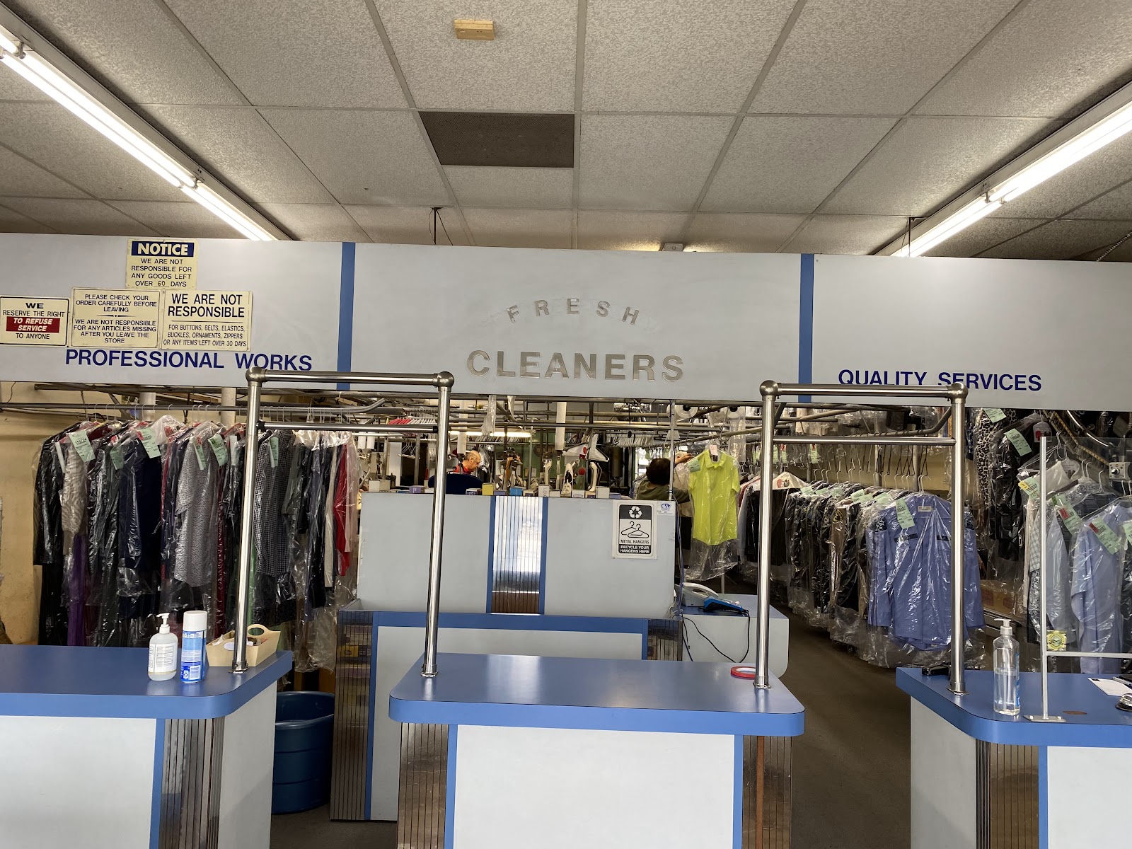 Interior of the Lucy's Cleaners store with a front counter and garment conveyor