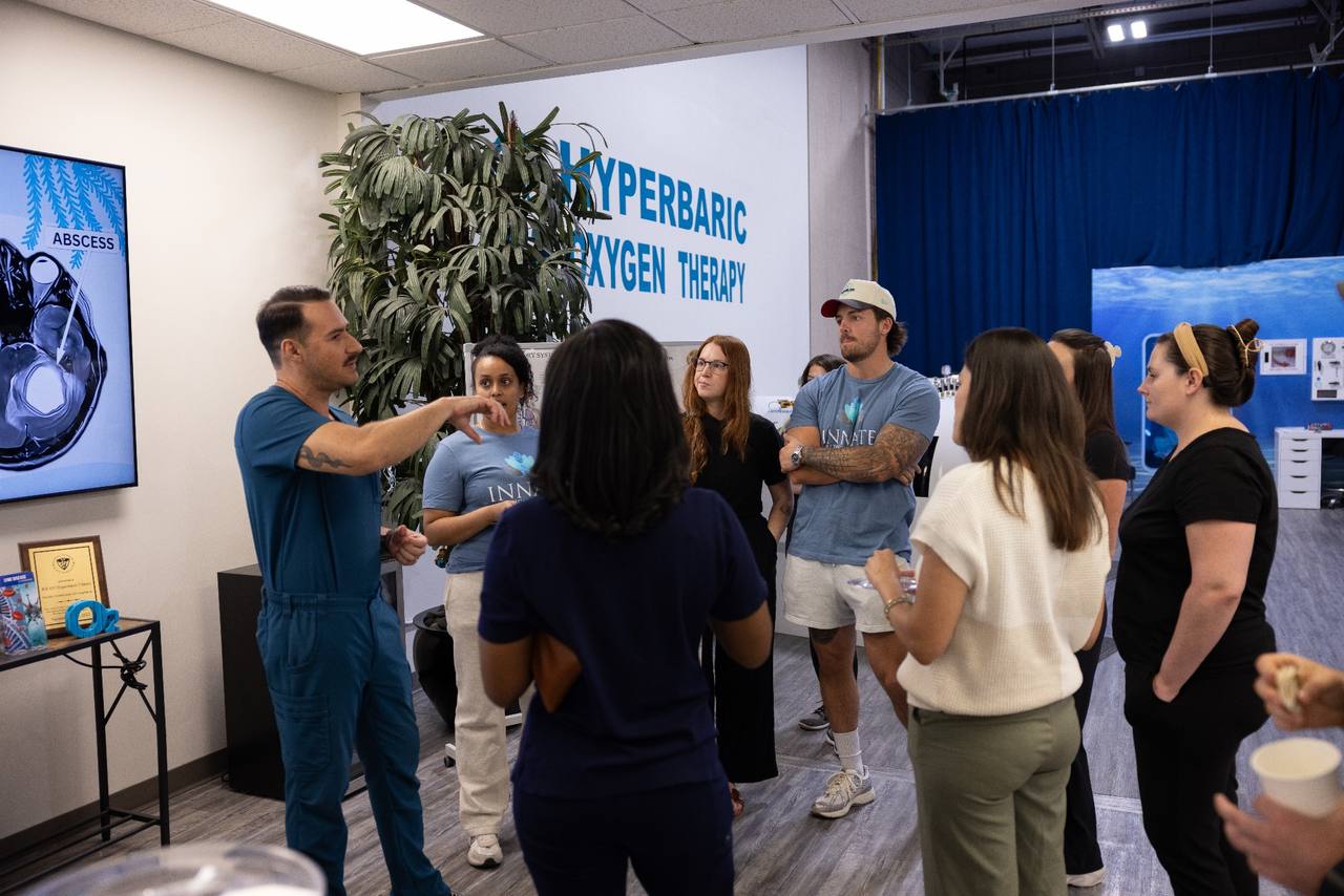 A hyperbaric training cohort discussing equipment with an instructor