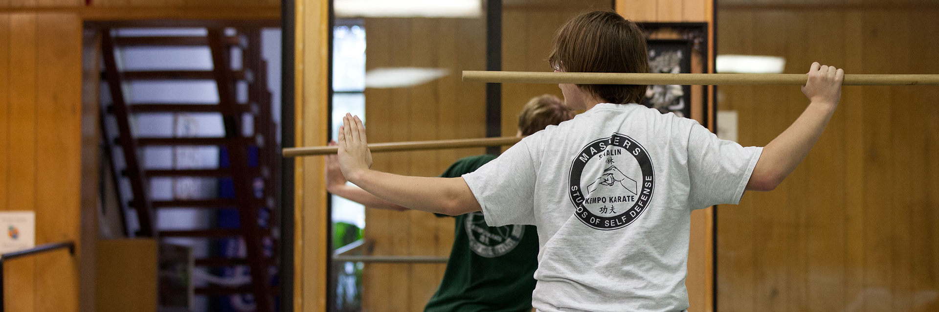 An instructor guiding a student in the dojo