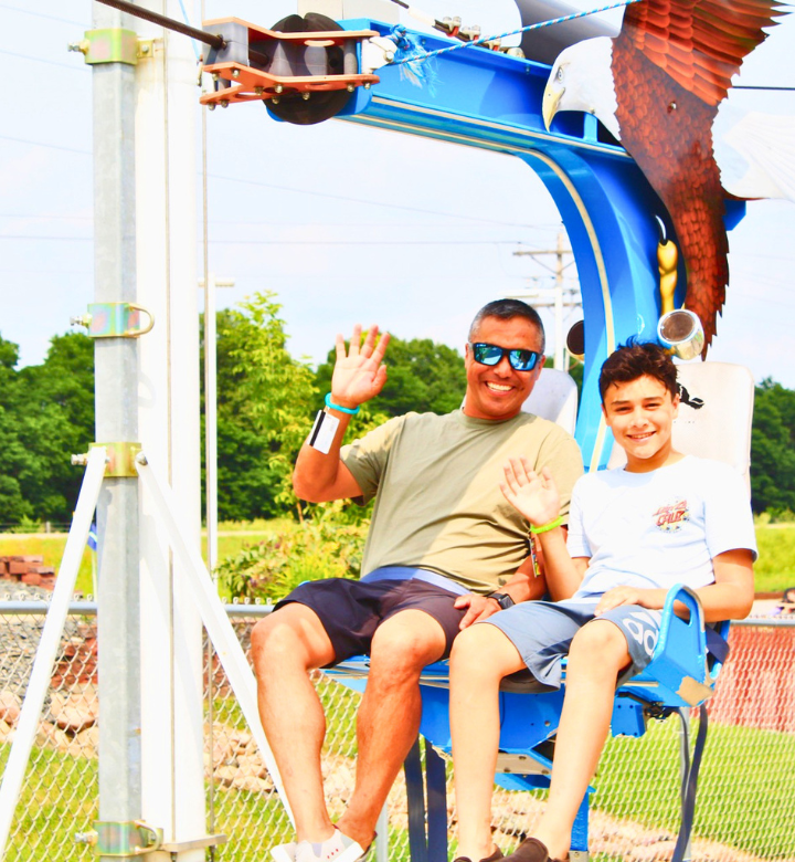 A father and son on the outdoor zipline at Action City in Eau Claire, WI. A father and son on the outdoor zipline at Action City in Eau Claire, WI.