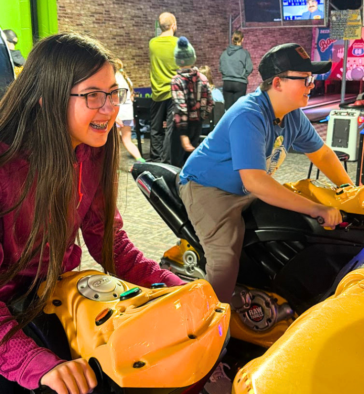Siblings racing against each other in the Action City Arcade.