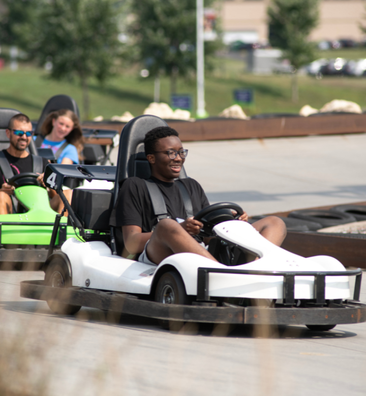 Teenager driving outdoor go-karts at Action City