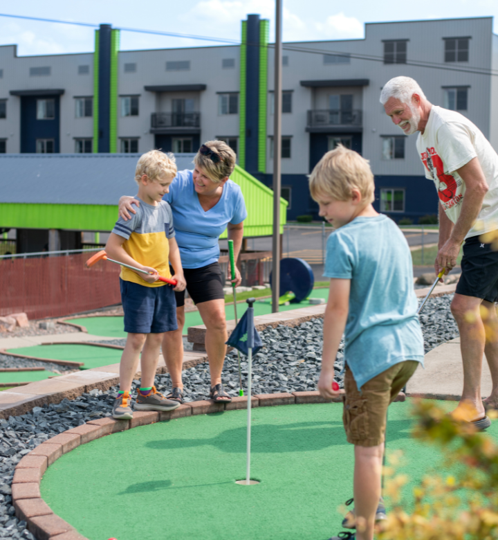 Grandparents mini golfing with grandkids at Action City in Eau Claire, WI.