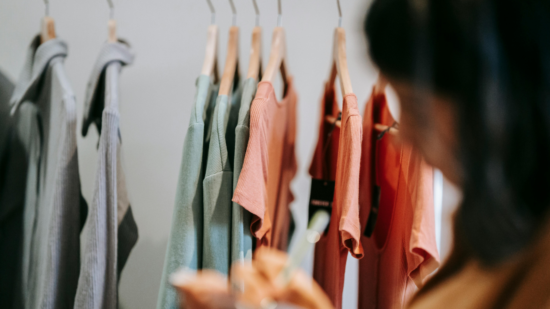 Consumer reviewing apparel products in a clothing store, highlighting textile supply chain transparency and product accountability.