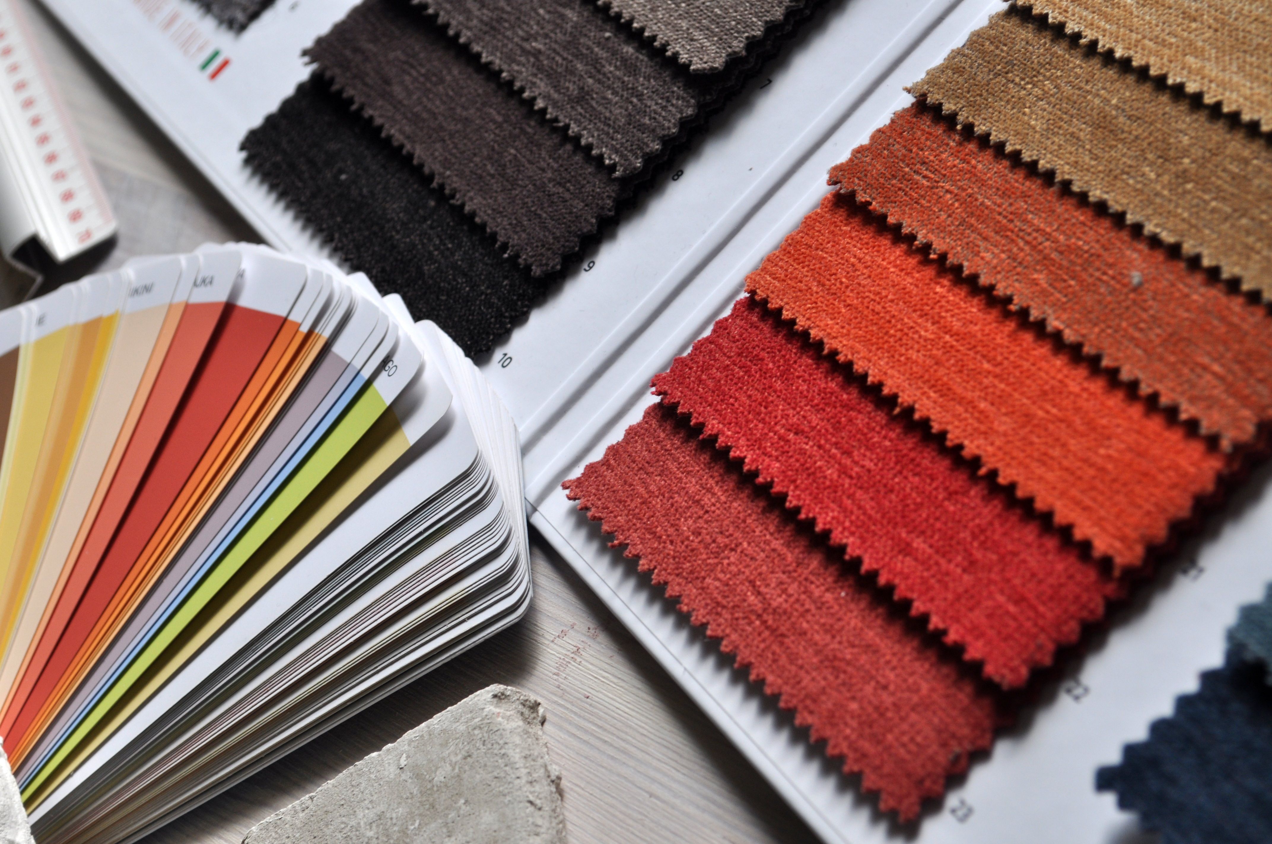 Fabric swatches and a color fan laid out on a designer's desk, illustrating the material composition records required for textile EPR readiness.