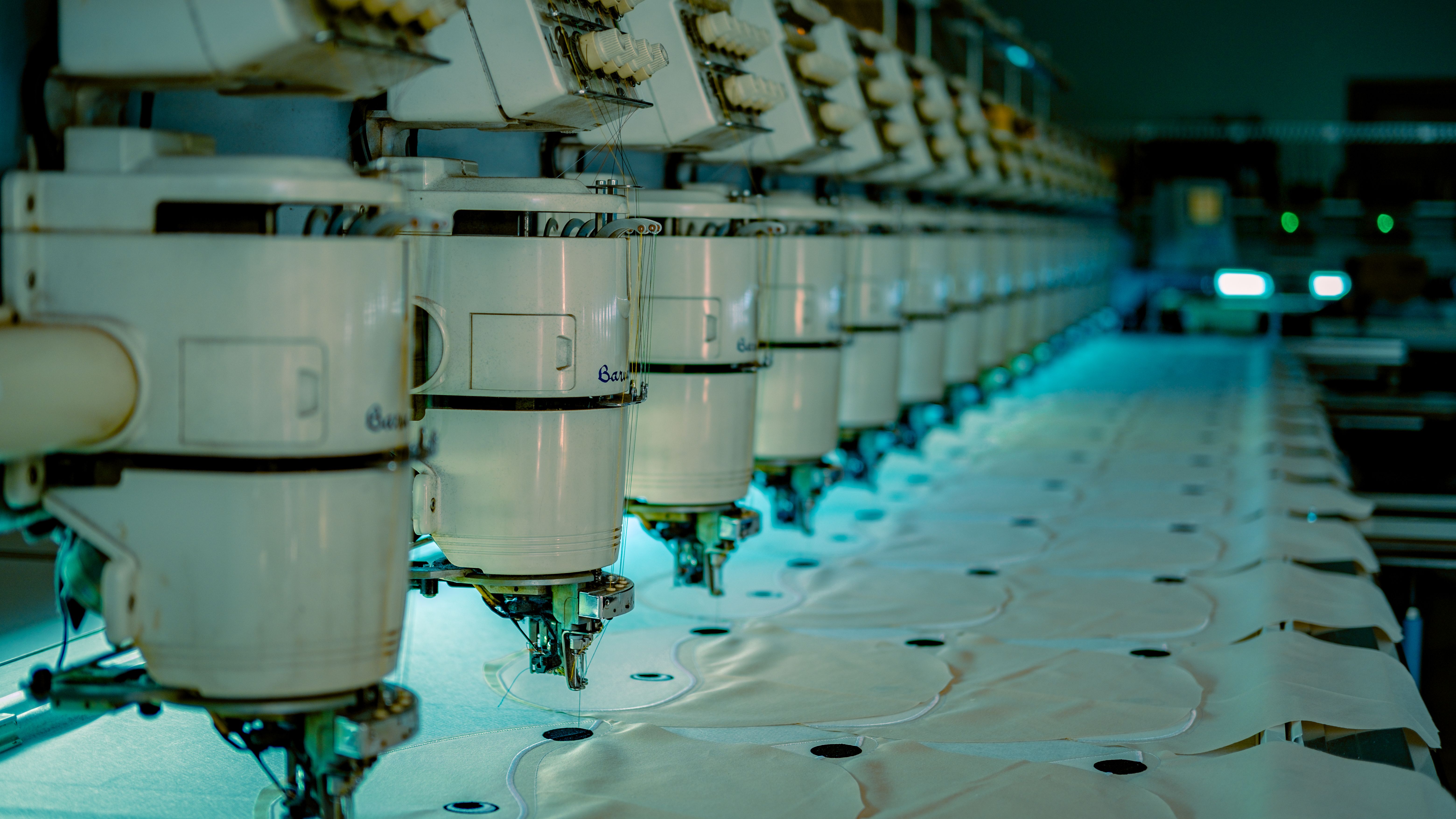 Industrial embroidery machines on an apparel production line, illustrating the supplier traceability work that textile EPR reporting requires.