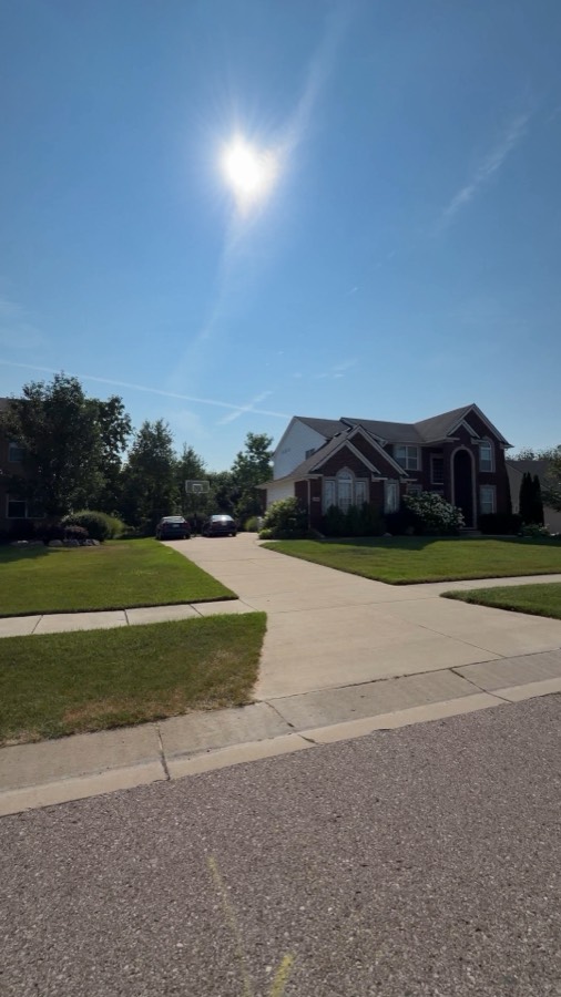 Brick colonial homes on a quiet subdivision street with sidewalks