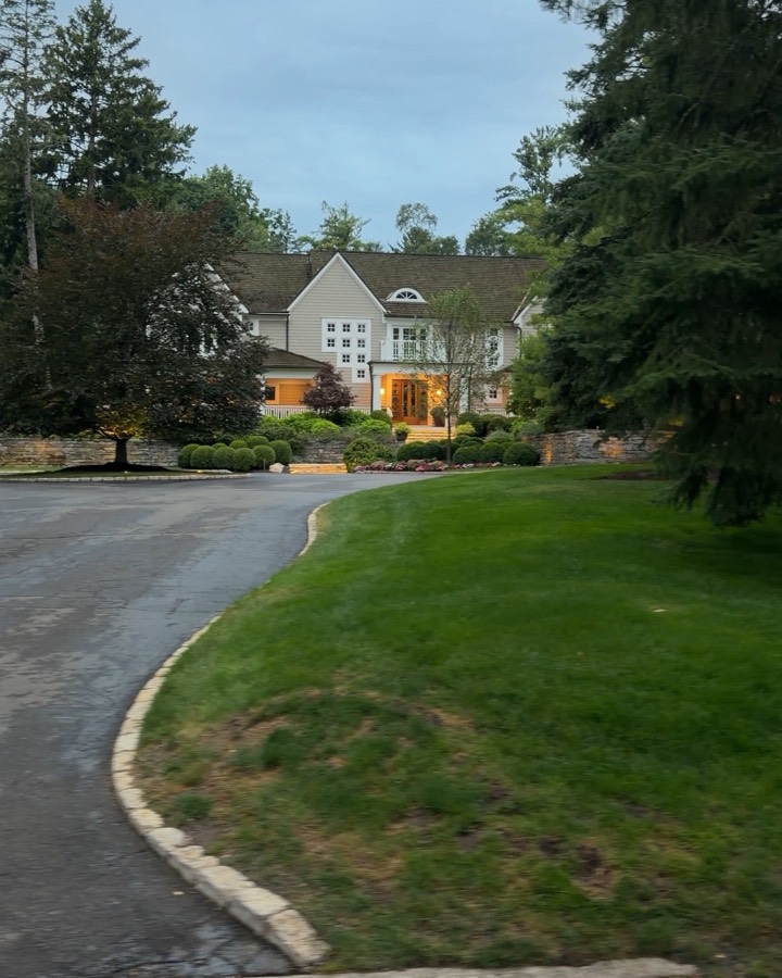 Winding private driveway leading to a large home surrounded by mature trees