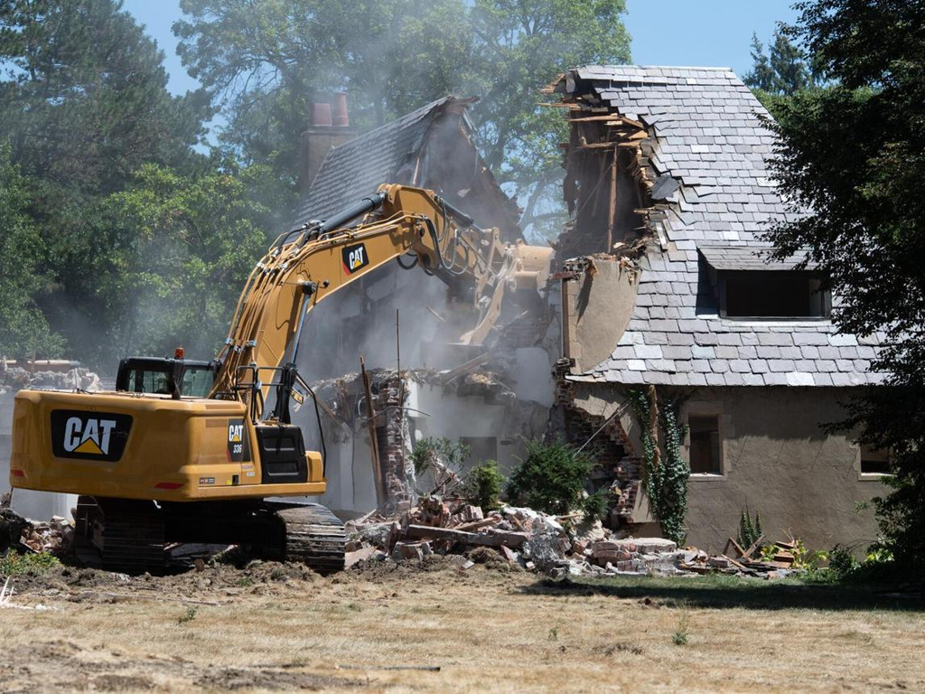 Excavator performing demolition work