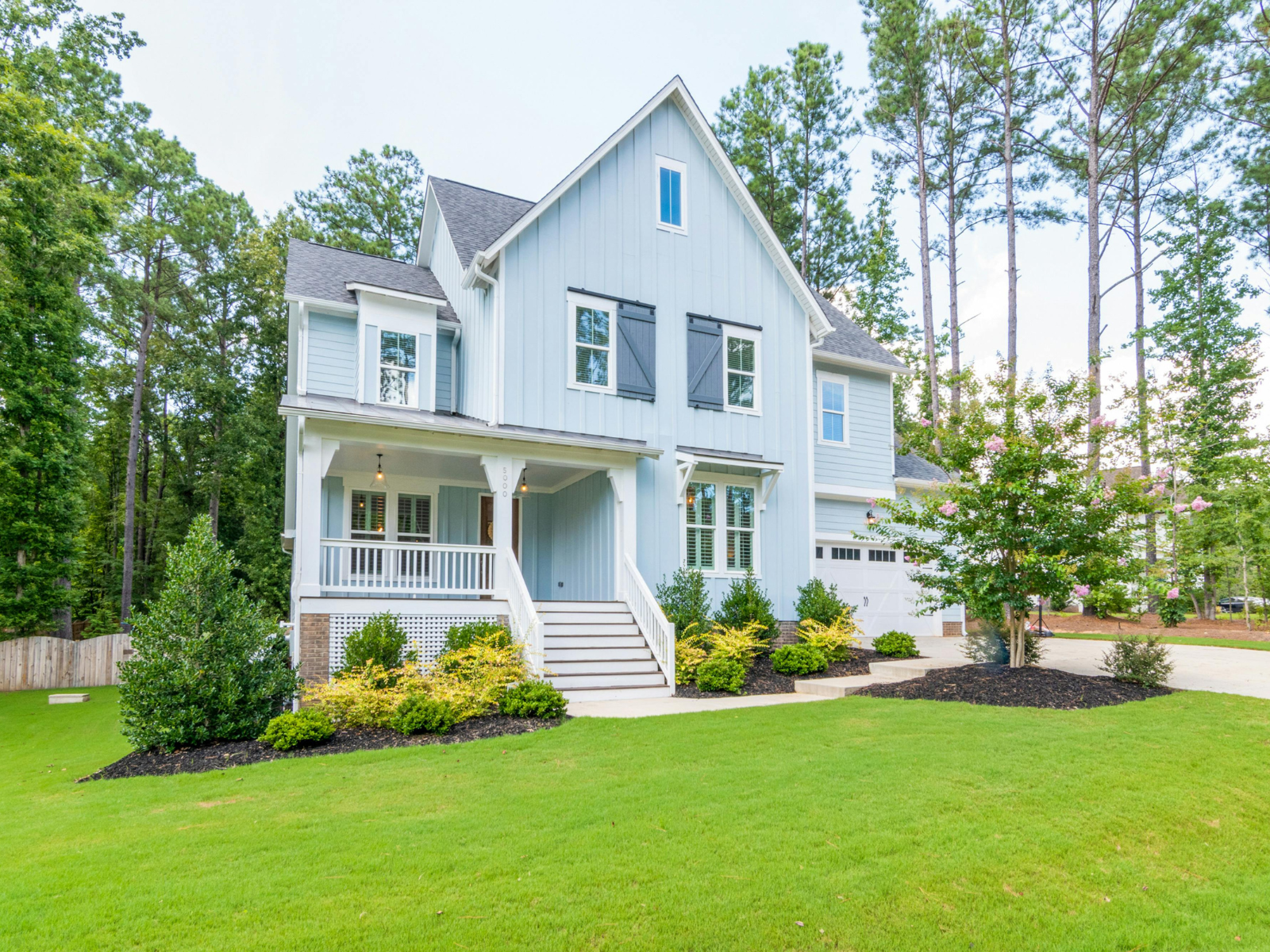 Heritage Lawn Care professional standing beside maintained lawn care equipment