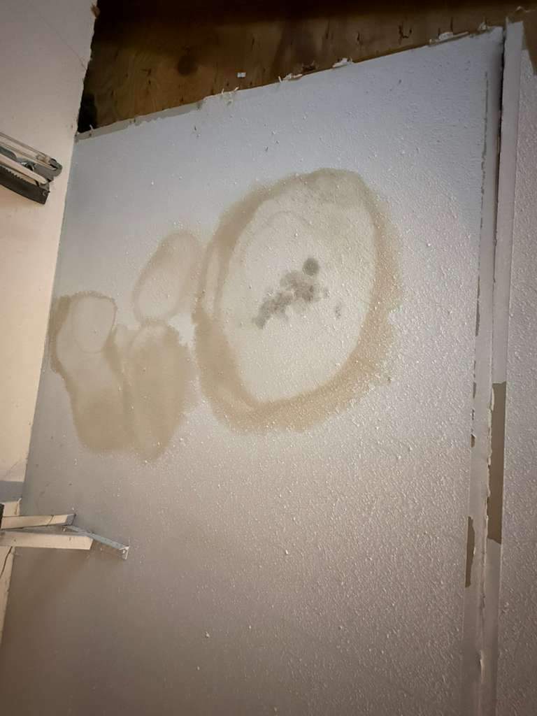 Interior wall or ceiling surface showing circular brown water stains and discoloration at Lake Champlain San Antonio home