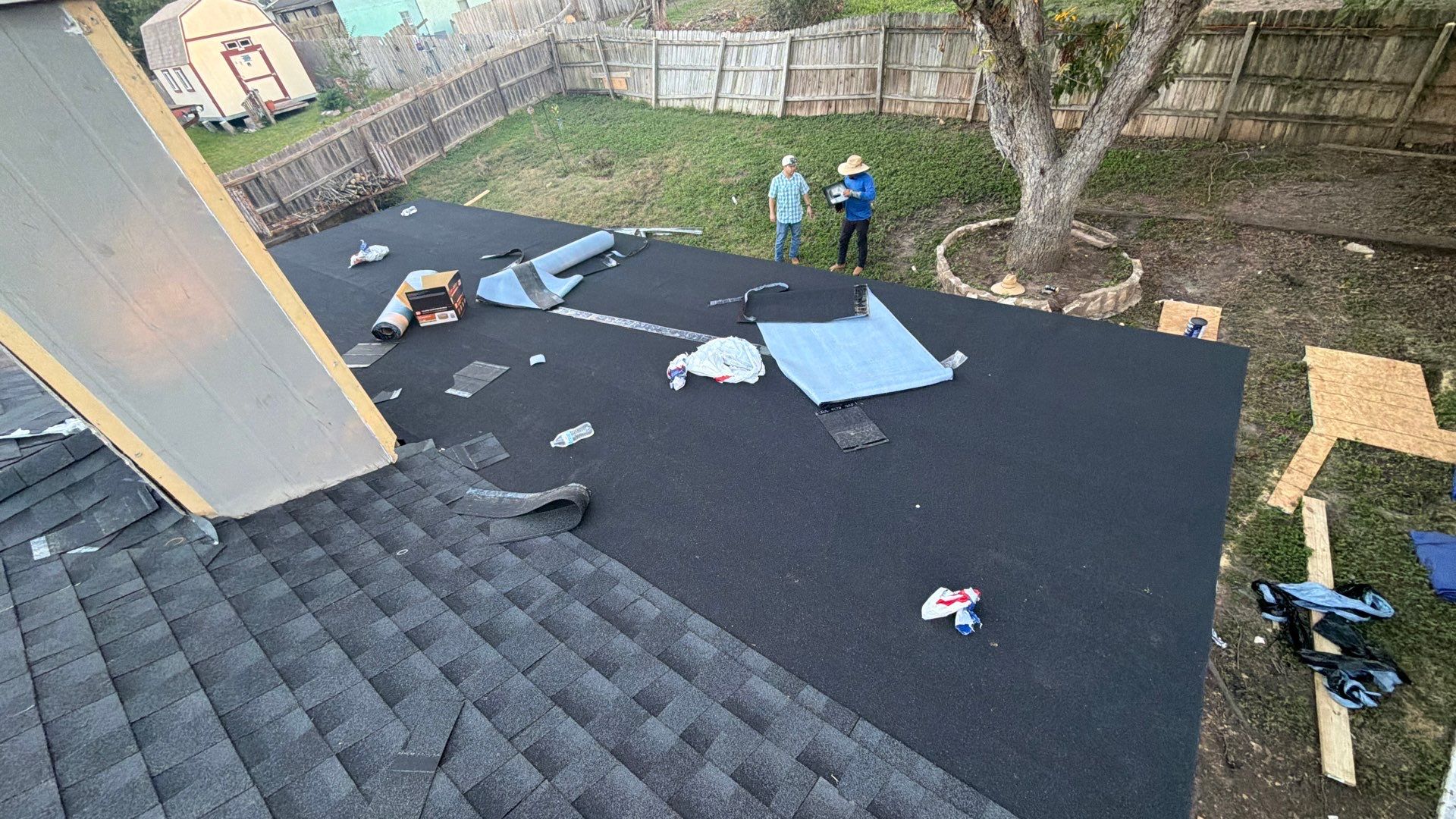 Roofing workers and underlayment visible during residential roof restoration work in the Lake Champlain area of San Antonio