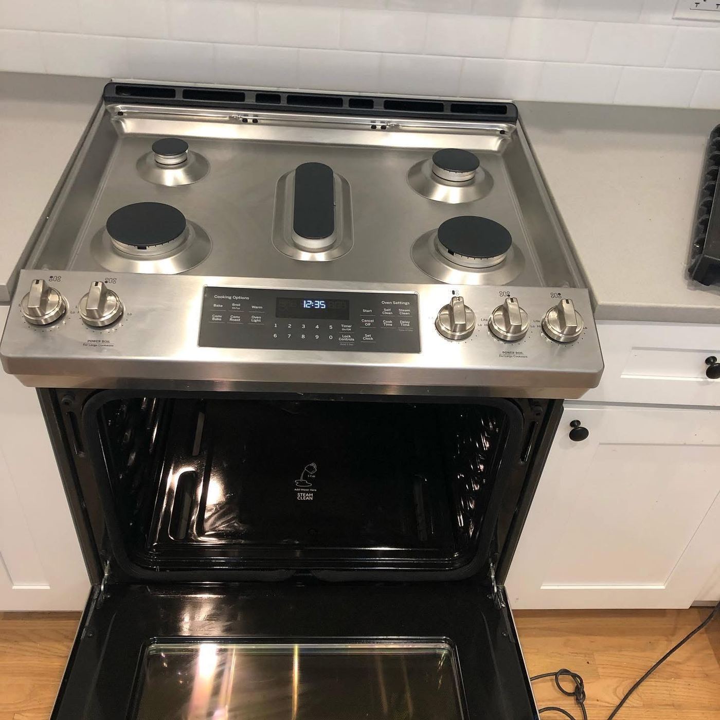 Stainless steel gas range with spotless oven interior after kitchen deep cleaning