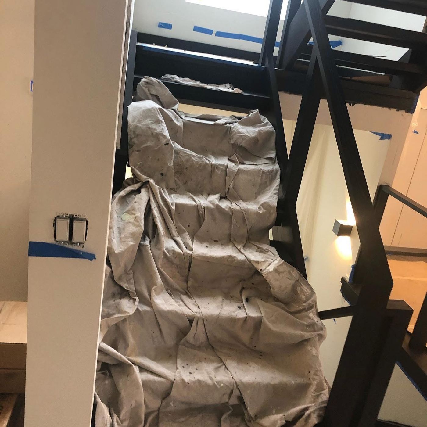 Staircase covered with protective drop cloth during construction