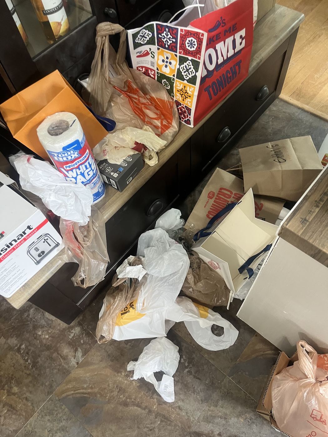 Trash bags and boxes piled in a room before junk removal